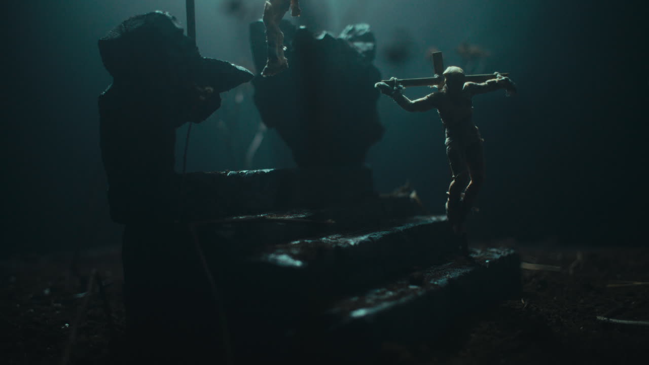 A miniature mummified doll hanging on the gallows at night