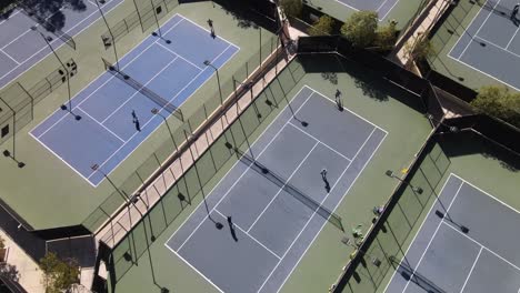 Aerial-view-over-people-playing-tennis,-Top-down-rising,-Valencia,-CA