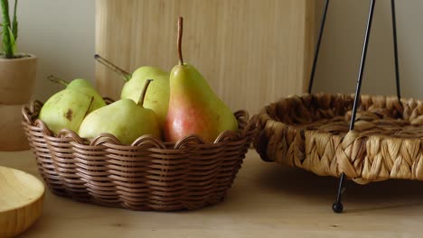 pears in a woven basket on a wooden table
