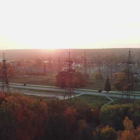view of the site with high-voltage lines on the background of the road and trees at sunset. camera motion forward. aerial view