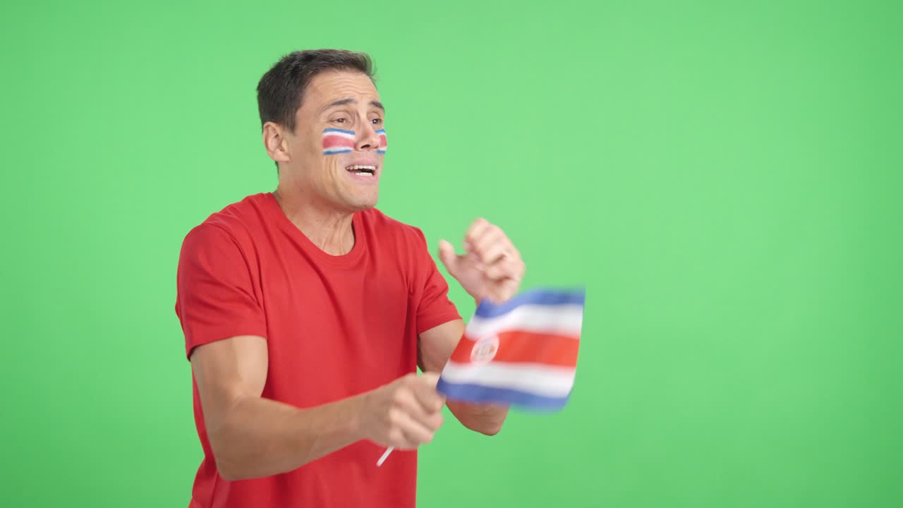 Nervous man cheering for Costs Rica during a match looking away