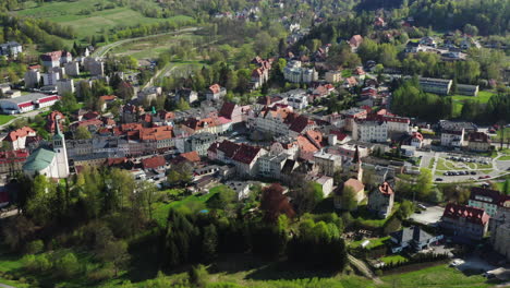 Aerial-reveal-of-historic-European-town-in-valley-with-modern-road-ring-and-5G-mast