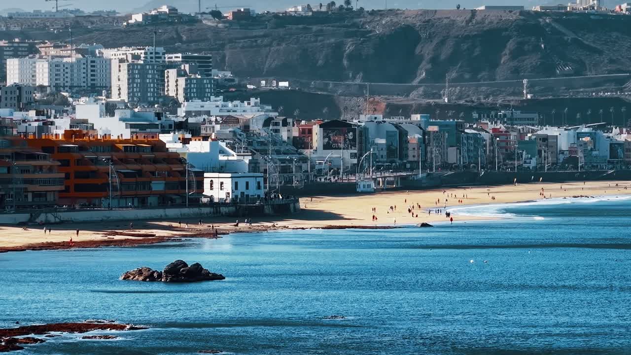 Vista costiera di Gran Canaria con persone che passeggiano lungo la spiaggia