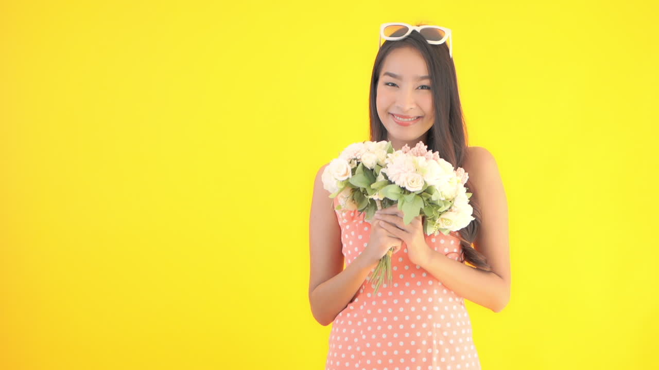 Lovely classic styled asian model smelling flowers
