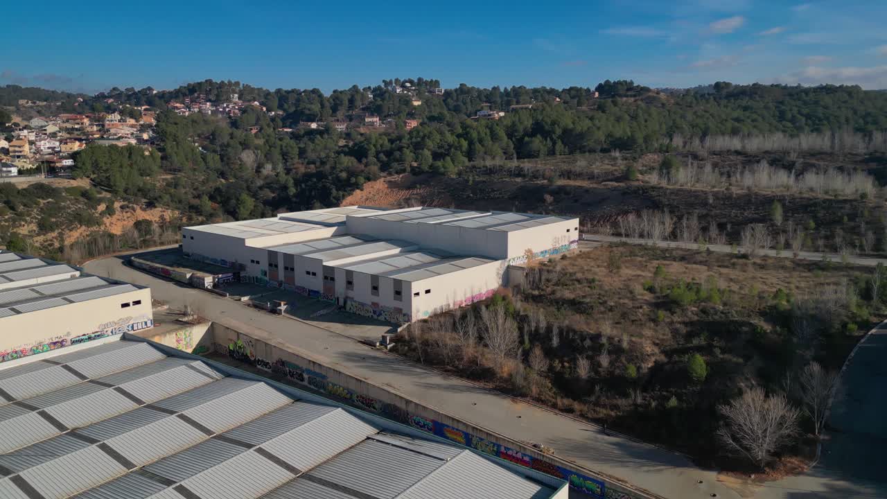 Industrilagre nær skovområde i Abrera, Barcelona, Spanien, under klar himmel, luftfoto