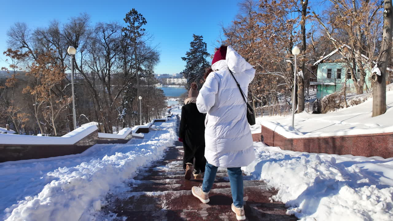 People walking on white snow at Valea Morilor lake park in Chisinau, Moldova