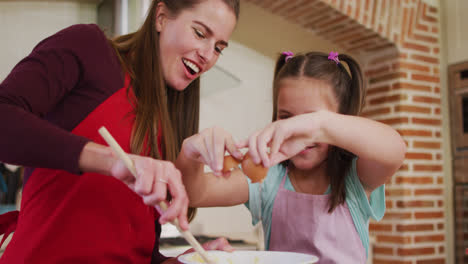 Kaukasische-Mutter-Und-Tochter-Tragen-Schürzen-Und-Backen-Gemeinsam-In-Der-Küche-Zu-Hause