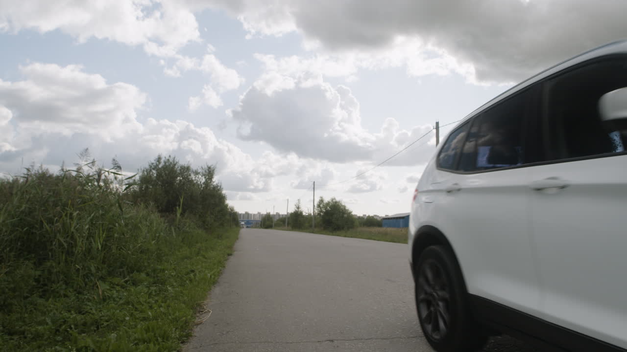 SUV driving on a road under a cloudy sky