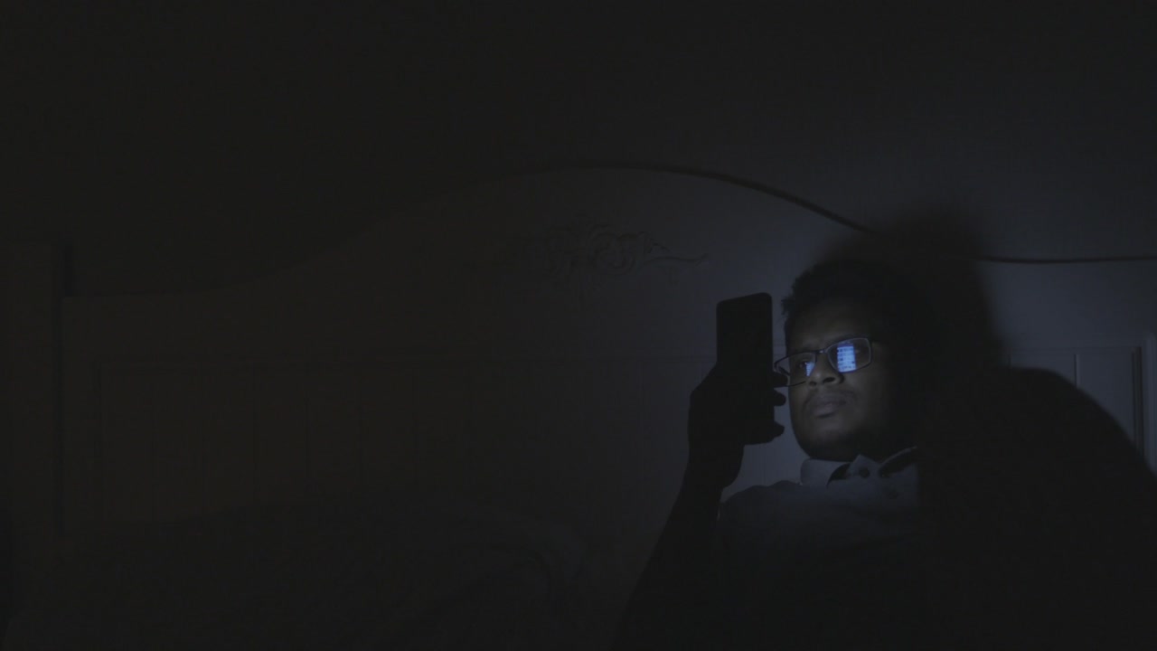persona que utiliza el teléfono inteligente en la cama por la noche
