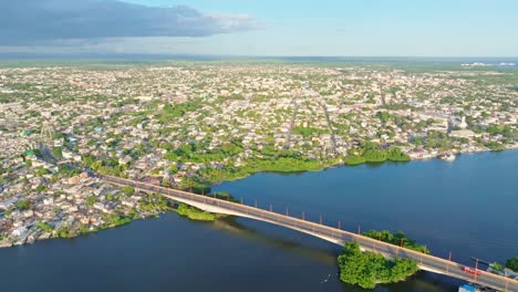 aerial view of suspension bridge crossing san pedro de macoris city during golden hour