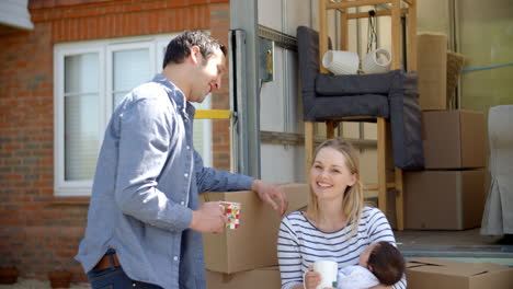 portrait of family on tail lift of removal truck moving home