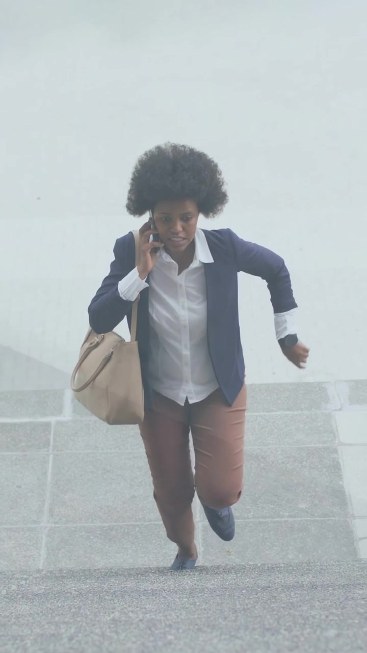 Vídeo vertical: Trabalhador com bolsa caminhando em direção à câmera, verificando a hora e apressando os passos para uma reunião no celular.
