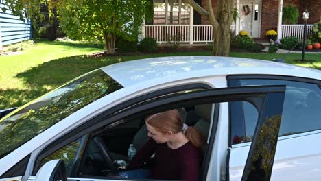 bientôt chauffeur, madelyne entre dans la voiture et sourit à la caméra