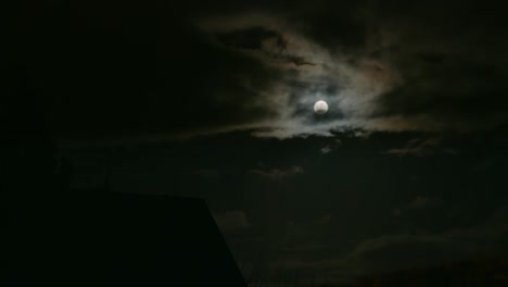 Bright-shining-full-moon-in-dark-clouds-in-East-Berlin,-Germany