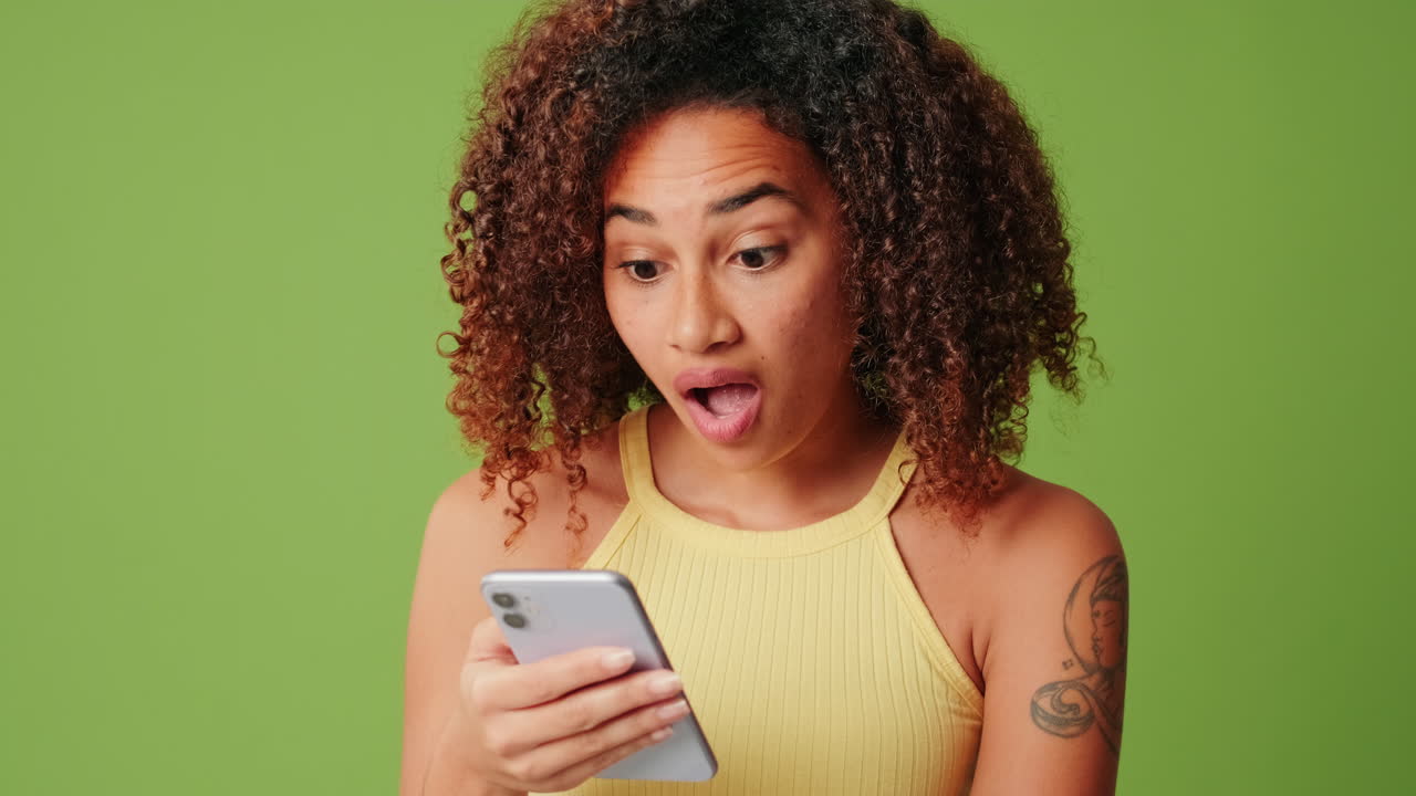 Young Woman Reacting with Surprise and Joy to Phone Content