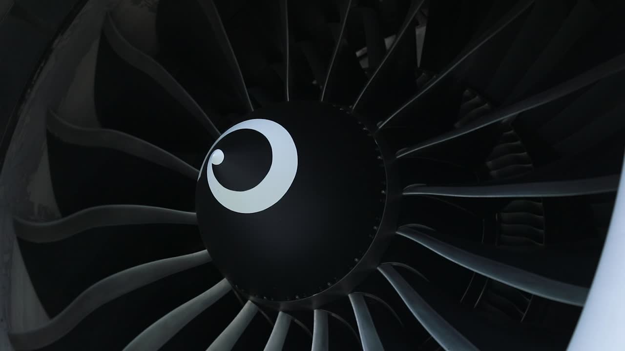 una ripresa ravvicinata cattura il motore dell'aereo che gira lentamente, mostrando i suoi dettagli intricati e la bellezza meccanica