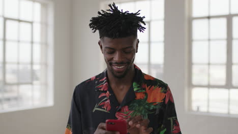 retrato de un hombre afroamericano relajado enviando mensajes de texto navegando por las redes sociales usando teléfonos inteligentes tecnología móvil sonriendo disfrutando de la comunicación digital