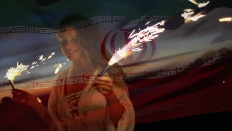 animation of waving flag of iran over group of friends having fun on the beach