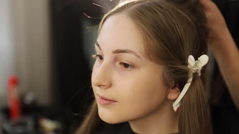 beautiful model having makeup applied during an intense professional photoshoot session