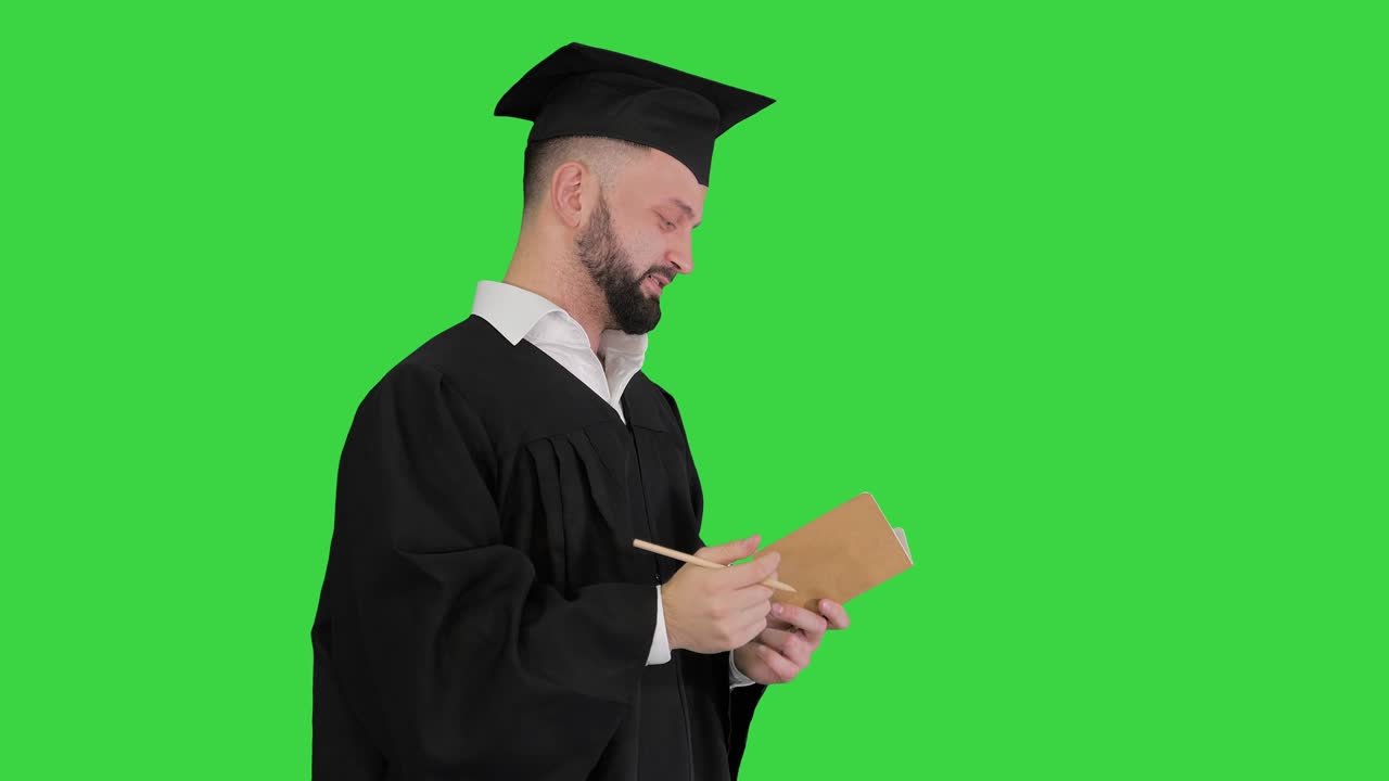 Uomo laureato pensieroso che annota i suoi obiettivi su uno schermo verde, Chroma Key.