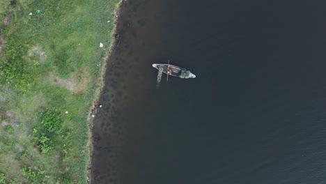 aerial view fisherman dropping nets and pots from boat along shore in vietnam