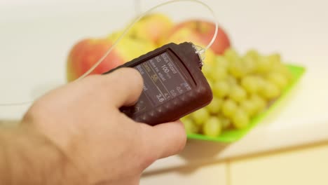 diabetic man with an insulin pump connected in his abdomen and holding the insulin pump at his hands. diabetes concept.