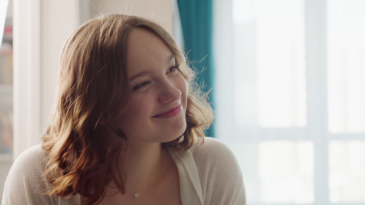 Caucasian Woman Seated By Window, Soft Morning Light, Gentle Smile And Thoughtful Gaze, Cozy Apartment Corner, Light Cardigan Over Tank, Subtle Necklace, Flipping Through Journal, Pausing In Daydream