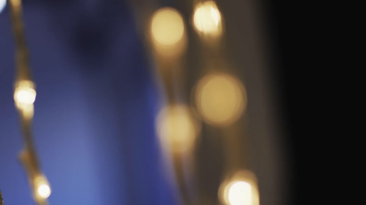 Video of flickering yellow bokeh spots of light with copy space