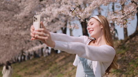 cheerful female taking selfie with her mobile phone at yangjae citizen's forest park in seocho district, seoul city, south korea