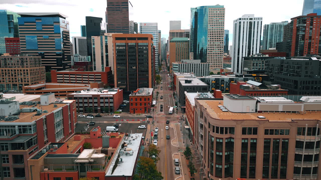 Denver, USA, 24 August 2025: Flight above the wide-lane street in the modern city. Approaching high-rise buildings in the downtown of Denver, Colorado, USA
