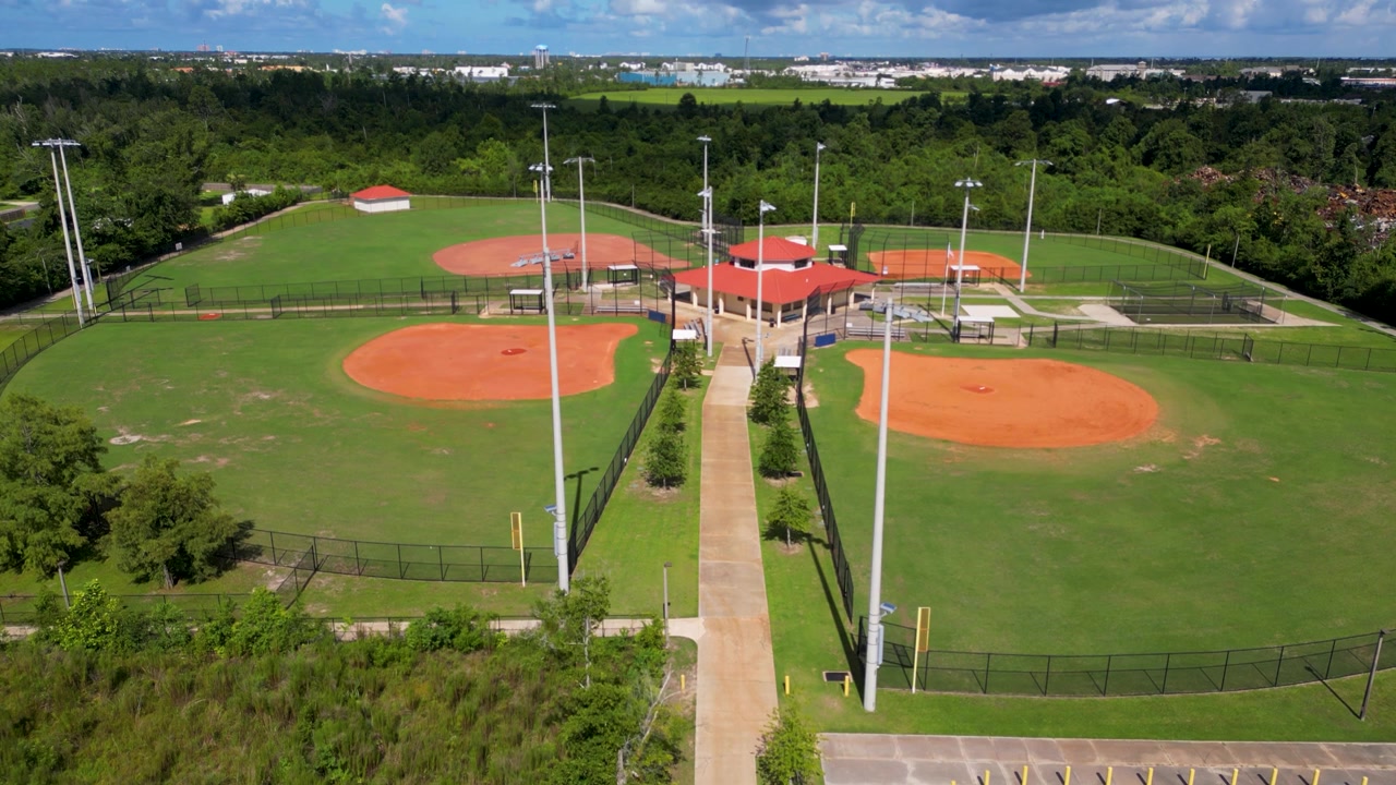 Ripresa con drone in lenta ascesa con quattro campi da baseball e struttura di ristoro.