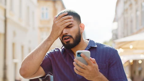 frustrated man looking at smartphone