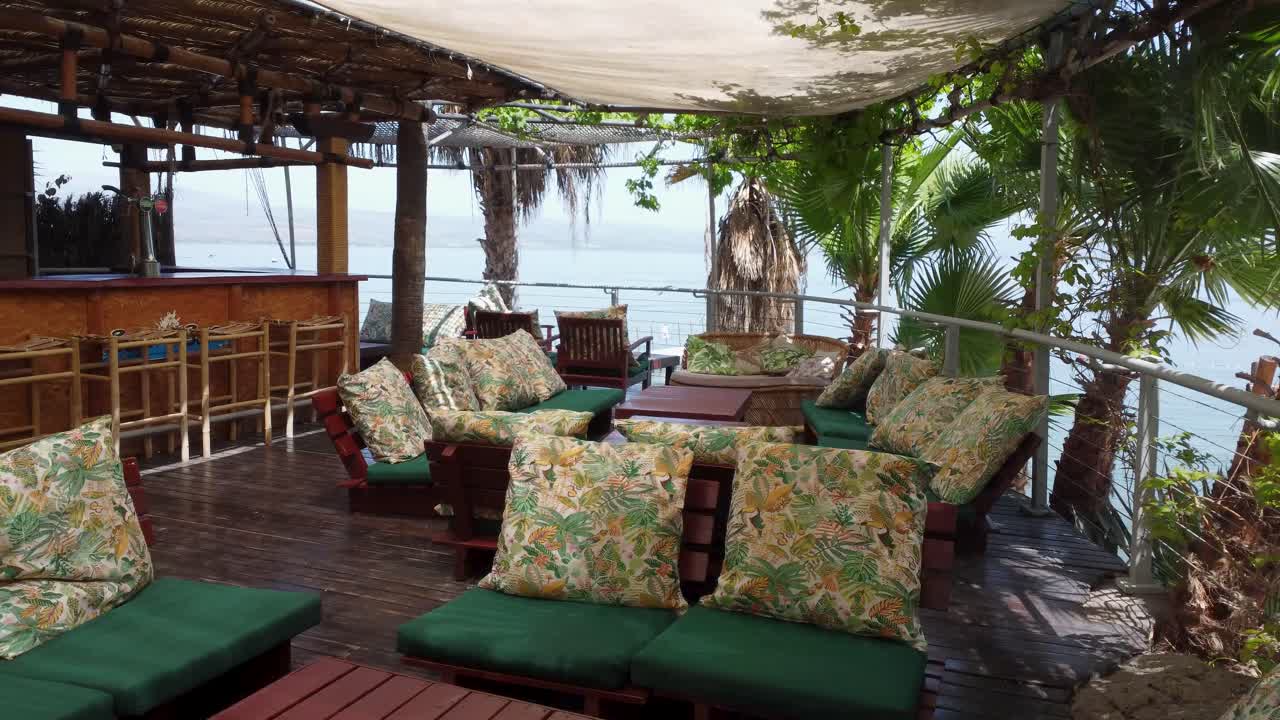 Aerial flythrough of outdoor beach bar with ocean view on sunny day in Lagos