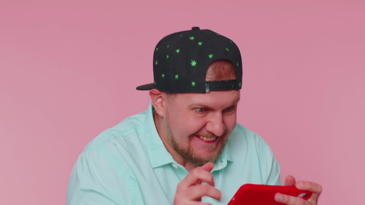 걱정스럽고 재미있고 중독된 관광객이  ⁇ 드폰으로 드라이브 레이싱 비디오 게임을 열정적으로 즐기고 있습니다.