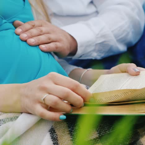 future parents read book in a meadow