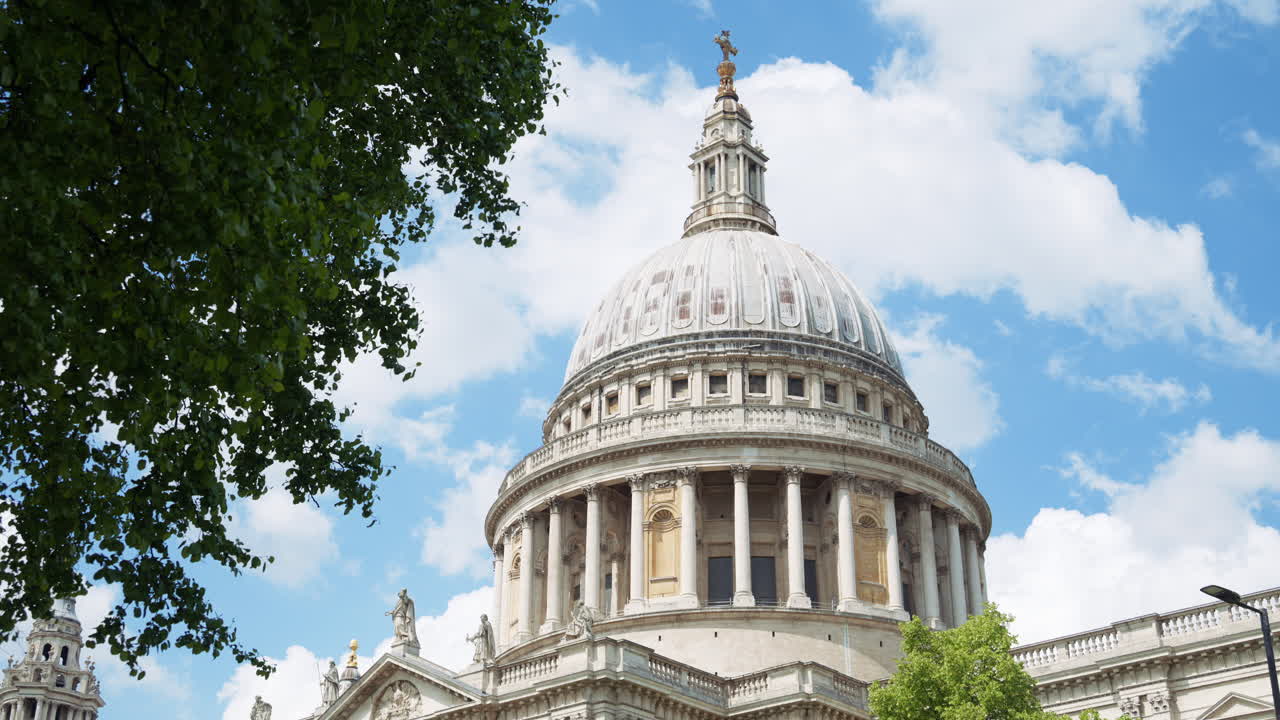 The Dome of St. Paul's Cathedral rising above the trees with a clear blue sky in the background in London, England