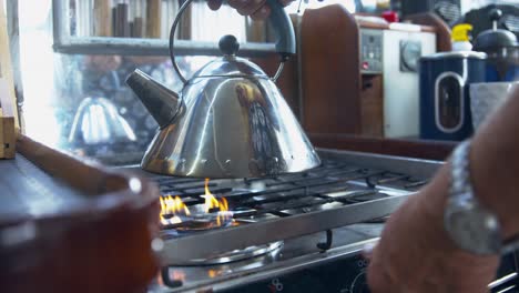 heat of the gas burner beneath the silver kettle brings water to boil