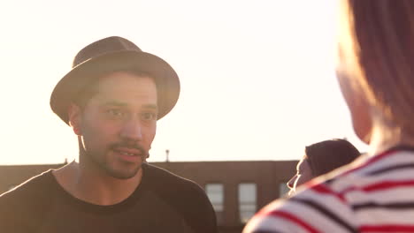 young adult friends talking at a rooftop party