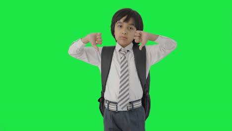 실망 한 인도 학교 소년 은 그린 스크린 을 내려 놓은 엄지손가락 을 보여 준다