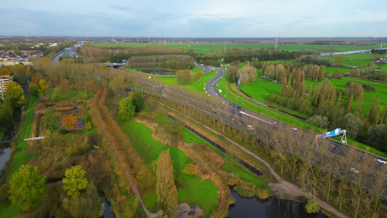 암스테르담 북부 에 있는 a10 암스테르담 고속도로 에 녹색 들 과 나무 들 이 둘러싸여 있다