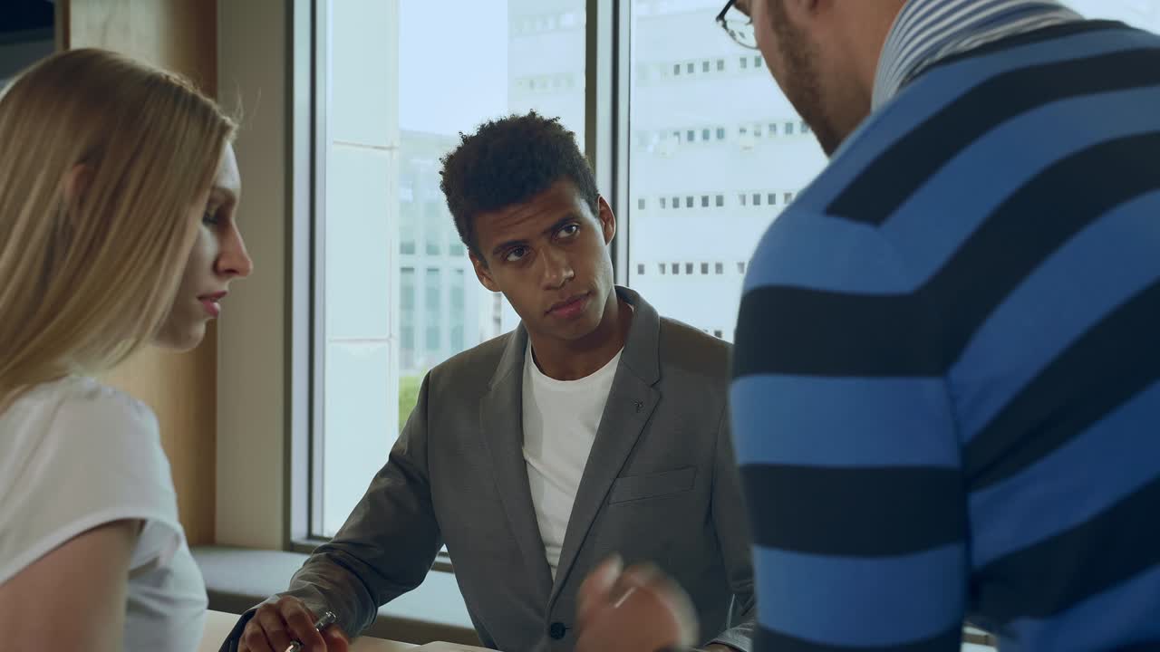 Group of diverse people in work process. Multiethnic men and woman discussing work issues while standing together in light room of office