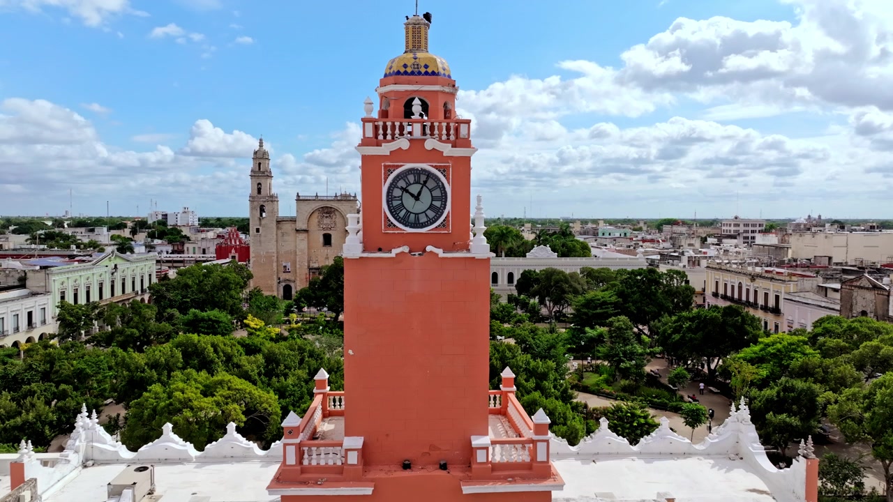 Meksika, Yucatan, Merida'nın merkezinde, tarihi şehir merkezinin üzerinde yükselen, saat kulesi olan uzun, kırmızı kolonyal bir binanın havadan görünümü