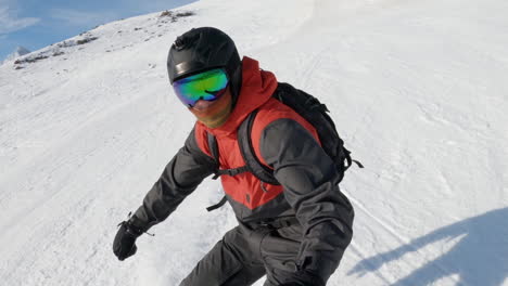 young male skiing down snow covered hill on snowboard, caucasus mountains, selfie portrait