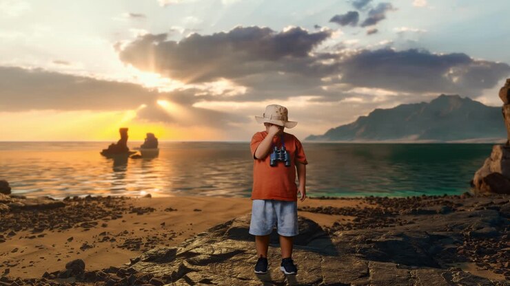 Asiatischer Junge mit Hut hat Kopfschmerzen, nachdem er durch das Fernglas geschaut hat. Jungenforscher untersucht etwas am Strand, Reise-Tourismus-Abenteuer-Konzept, Ganzkörperaufnahme