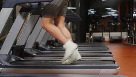 man running on treadmill in gym