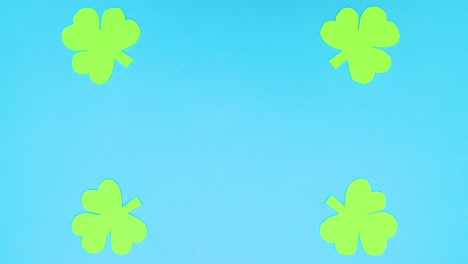 four green cloves moving from center to edges of blue background - stop motion