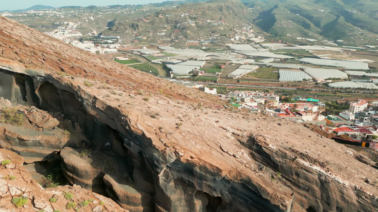 volando sobre la cueva de herrera ubicada en la montaña galdar y viendo la ciudad y sus cultivos de plátanos