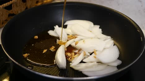 cooking with onions, ginger, and oil in a pan