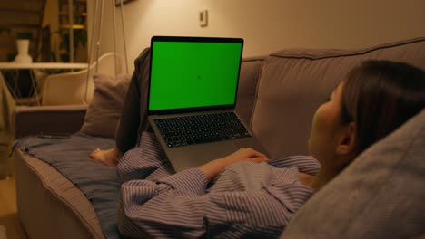 woman relaxing on couch watching something on laptop