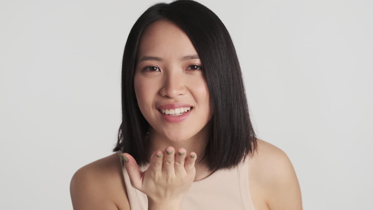 Wanita Asia meniup ciuman ke kamera